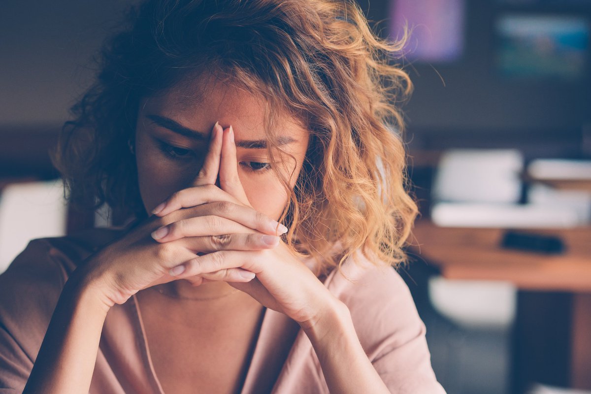A stressed young woman with her hands on her face.