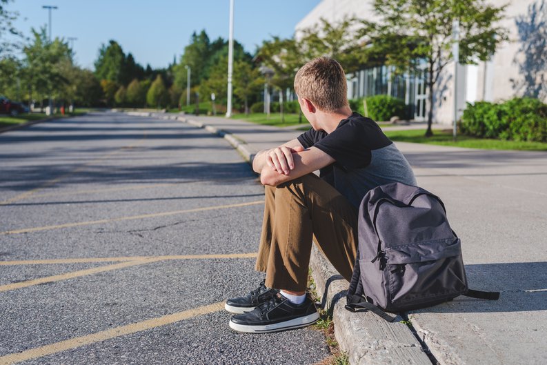 Student Sitting On Curb