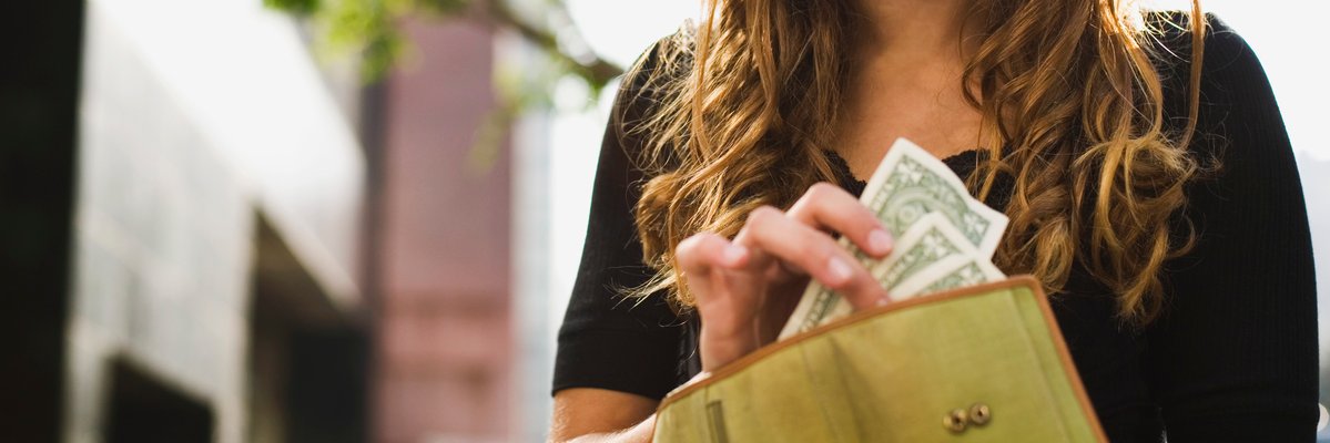 Teen taking cash out of her wallet.