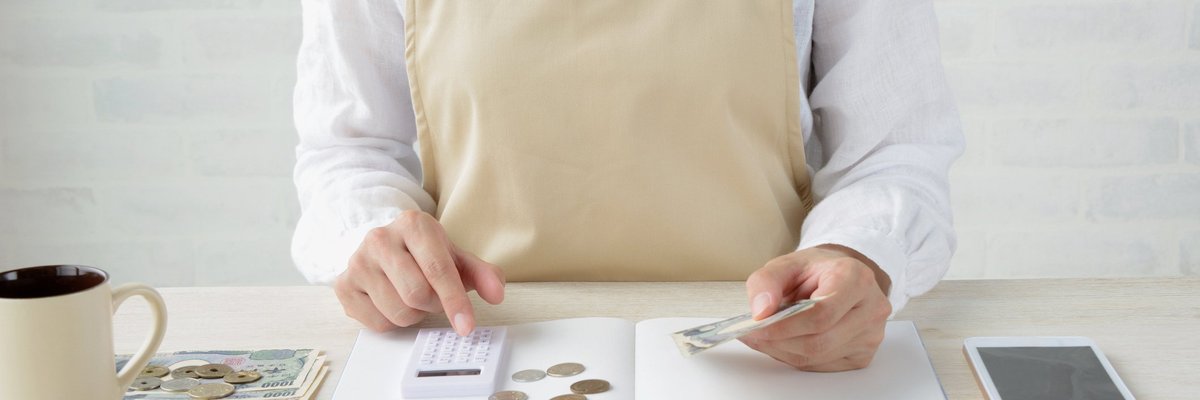 Person In White Room Organizing Coins And Bills While Using Calculator