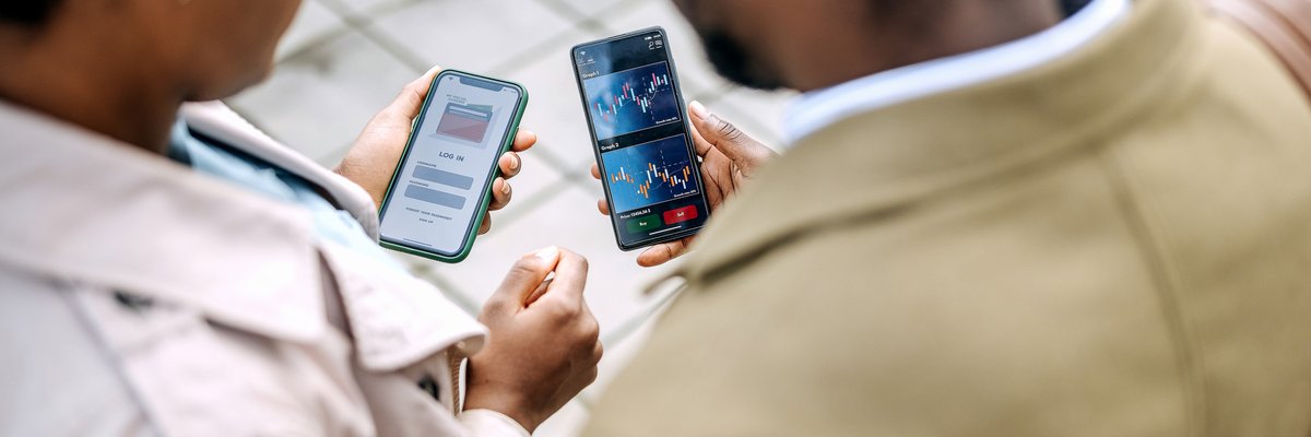 Two people looking at asset prices on investing apps.