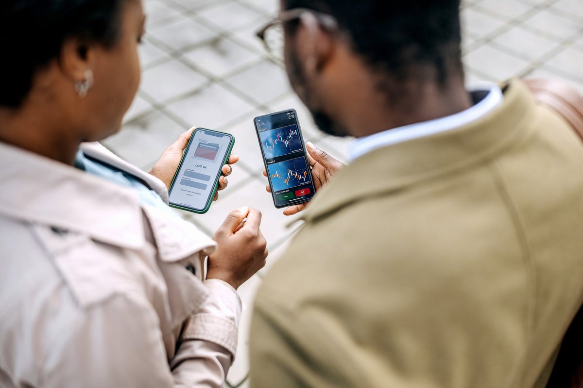 Two people looking at asset prices on investing apps.