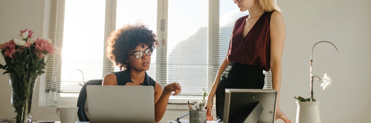 Two businesswomen having a discussion in an office.