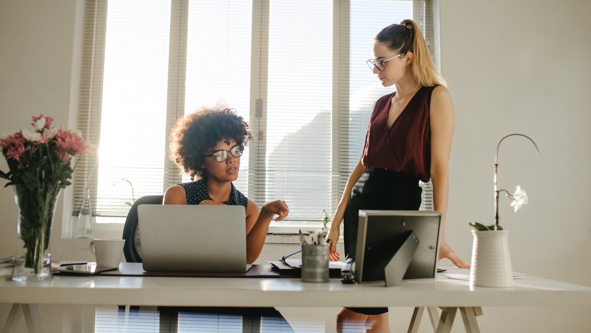 Two businesswomen having a discussion in an office.