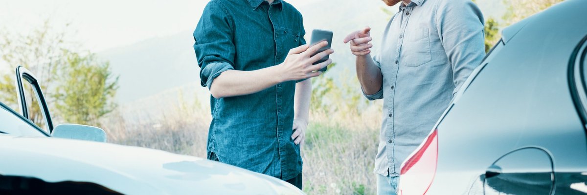 One Driver Taking Picture With Phone Of Car Accident While Other Driver Points At Phone.