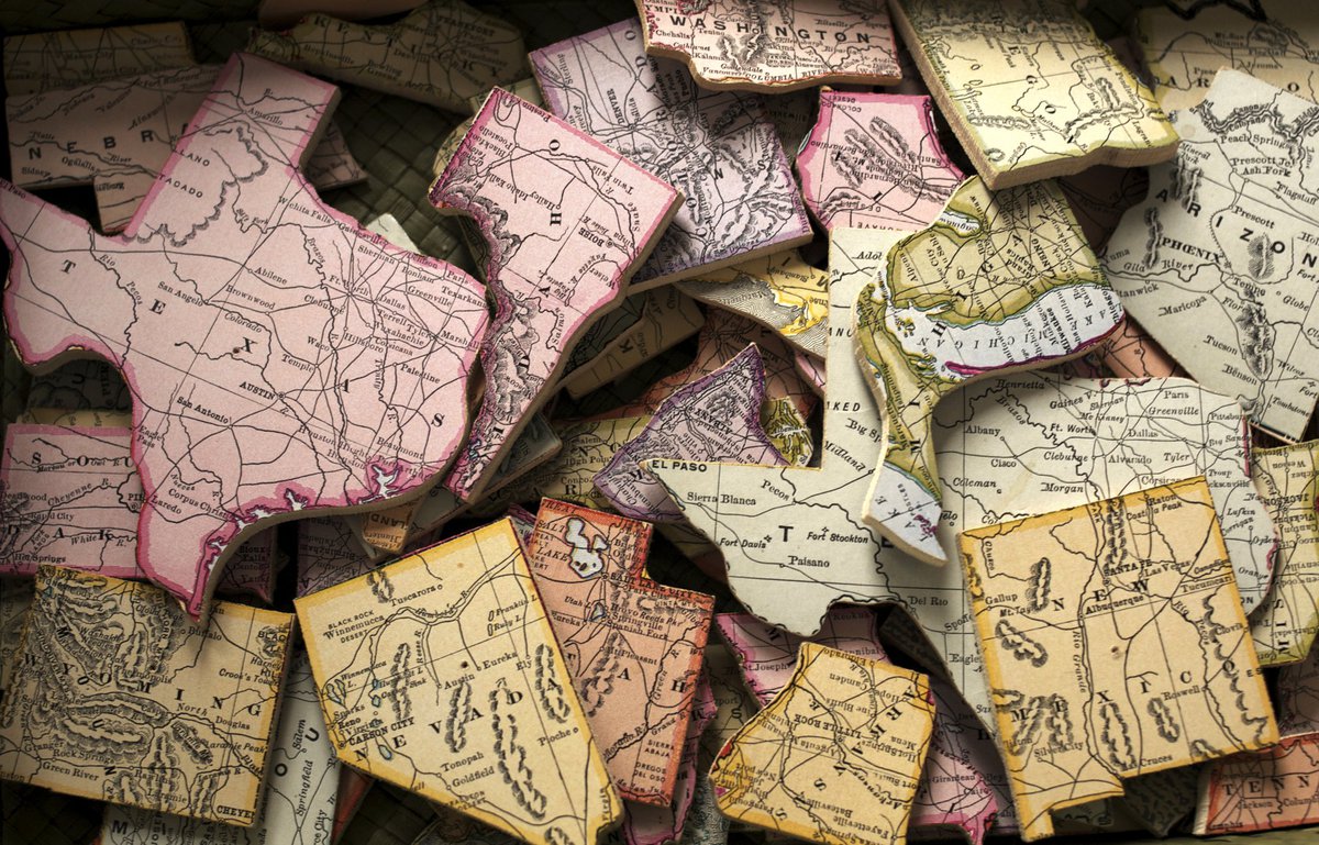 A pile of US states cut out of a map.
