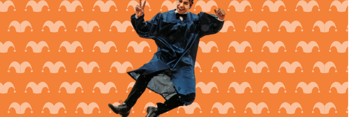 A man dressed in a cap and gown is jumping against an orange background.