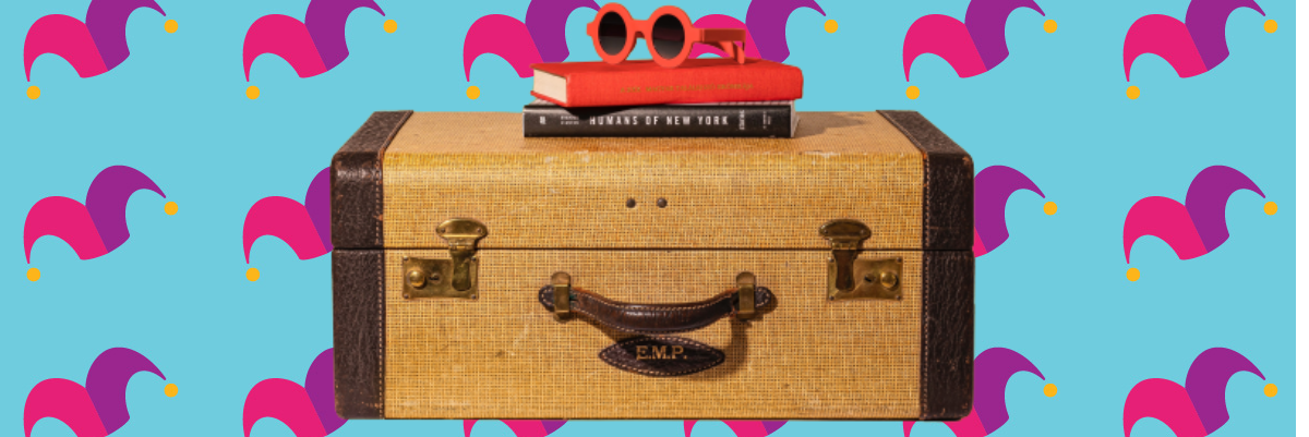 A suitcase with a book and pair of sunglasses on top of it.