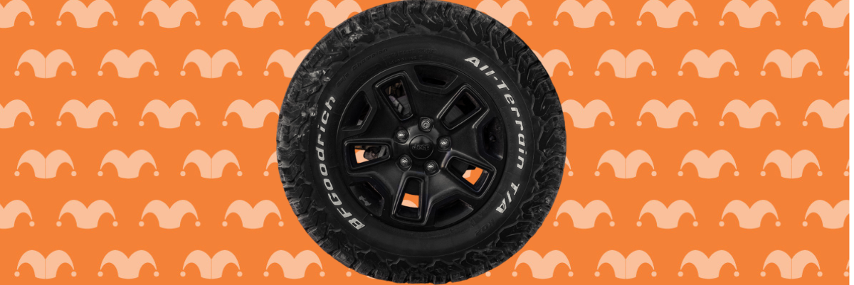 A car tire on top of an orange background covered in jester caps