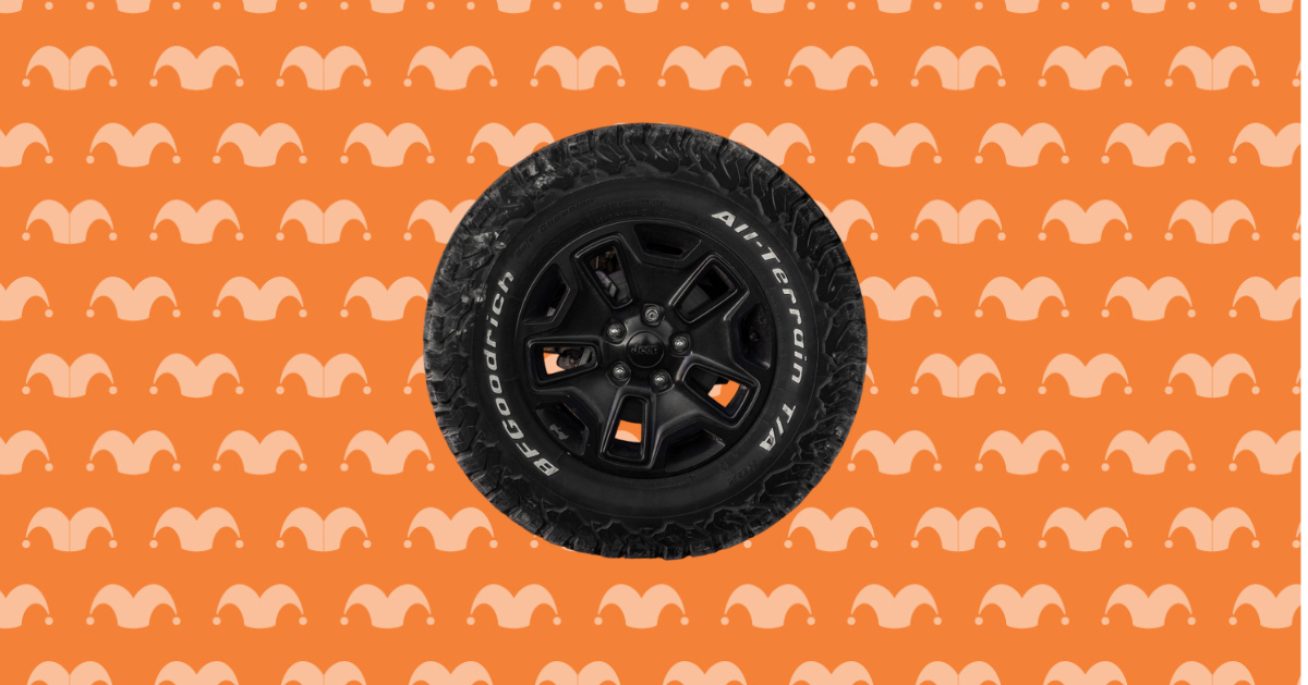 A car tire on top of an orange background covered in jester caps