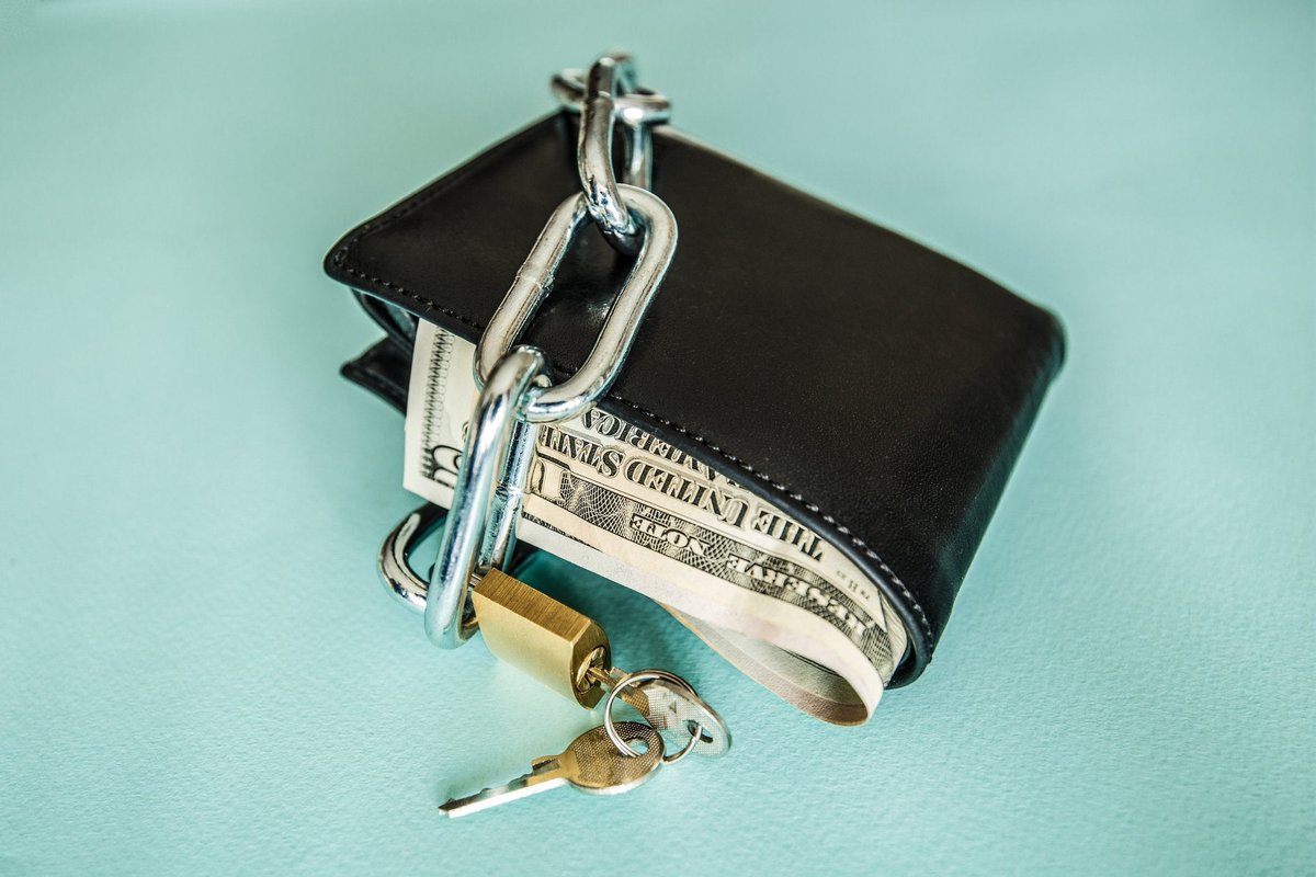 Sebuah dompet penuh uang dikunci dengan rantai dan gembok.