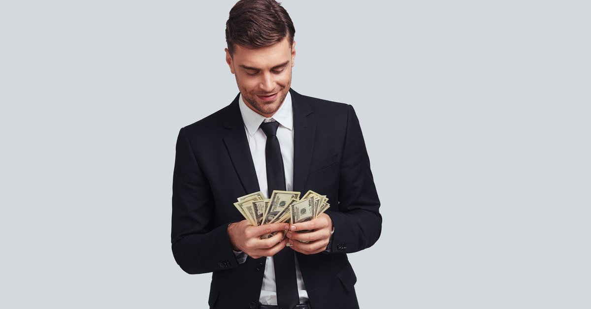 Wealthy man in a suit counting money.