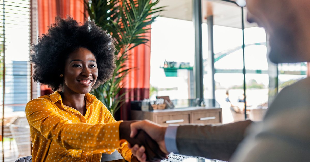 Well-dressed woman shaking hands with man in suit.