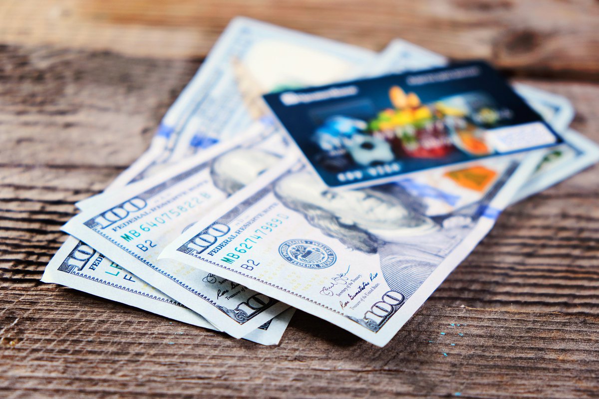 credit card atop stack of 100-dollar bills