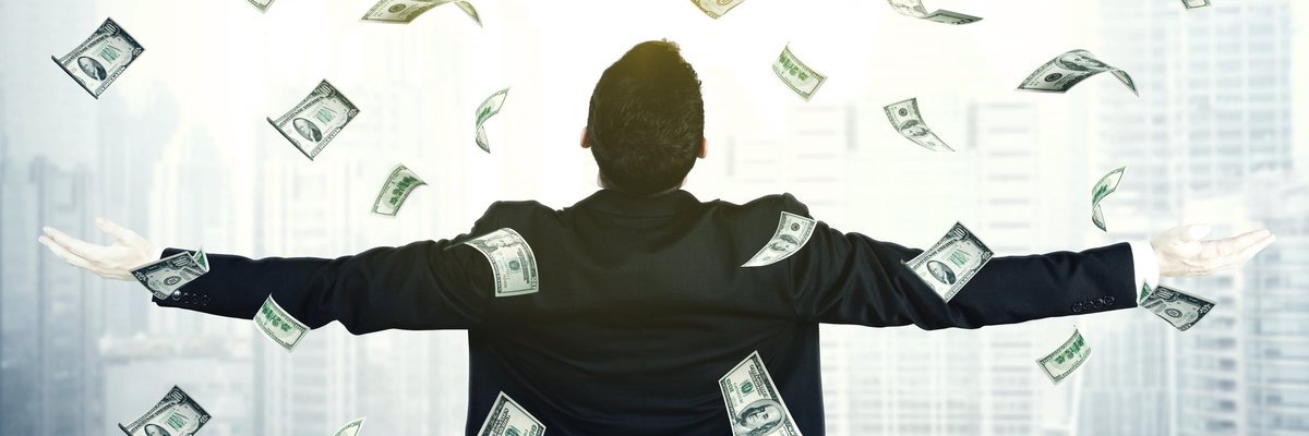 Man with arms outspread and cash raining down on him.