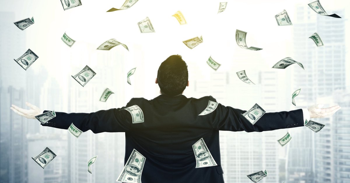 Man with arms outspread and cash raining down on him.
