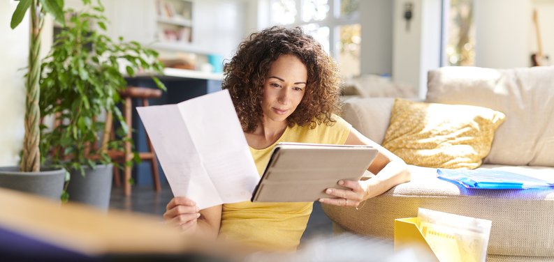 Woman With Paper Looking At Pad