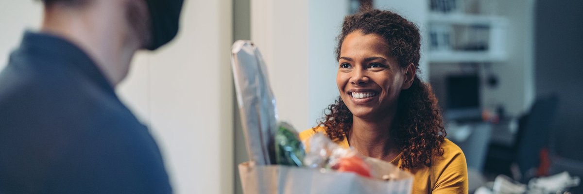 Woman accepting a delivery of groceries.