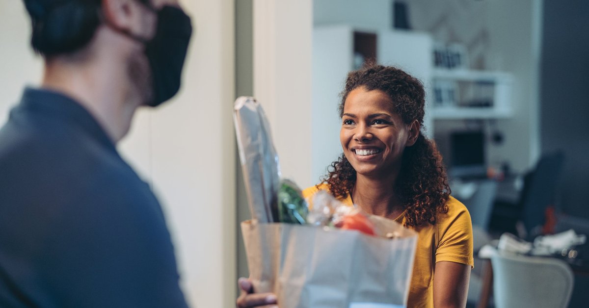 Woman accepting a delivery of groceries.