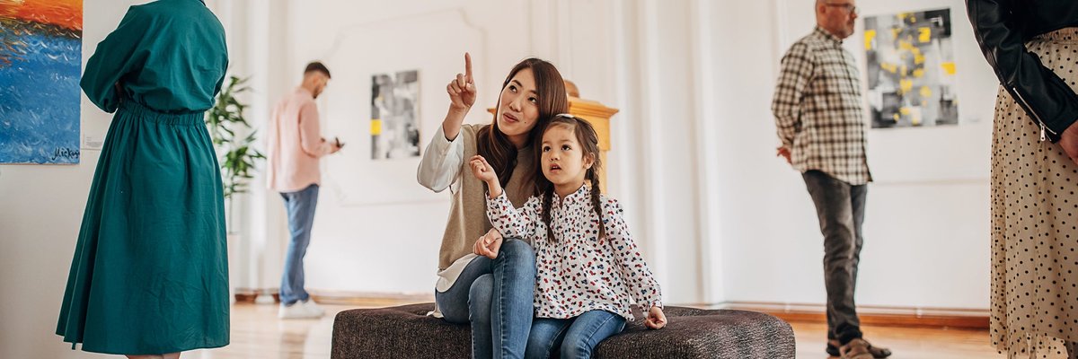 Woman and daughter looking at art in a museum.