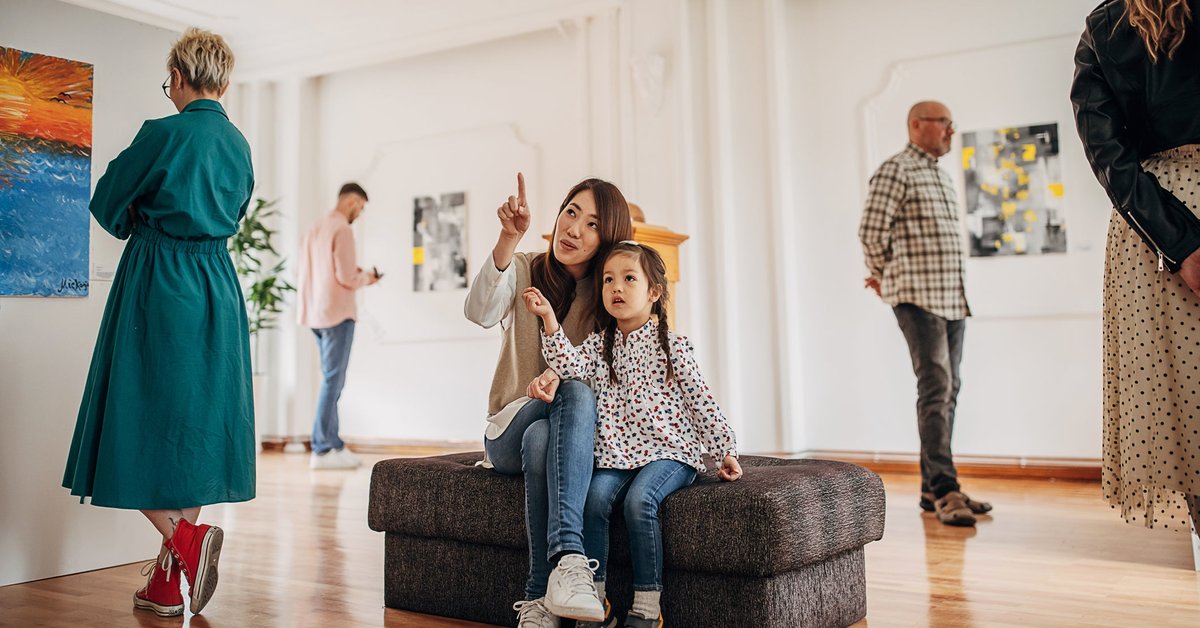Woman and daughter looking at art in a museum.