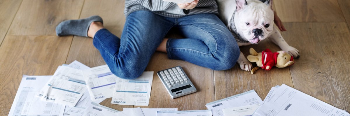 Woman and dog on floor with papers and calculator