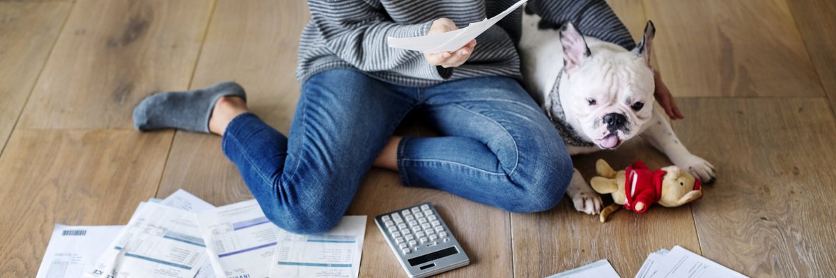 Woman and dog on floor with papers and calculator