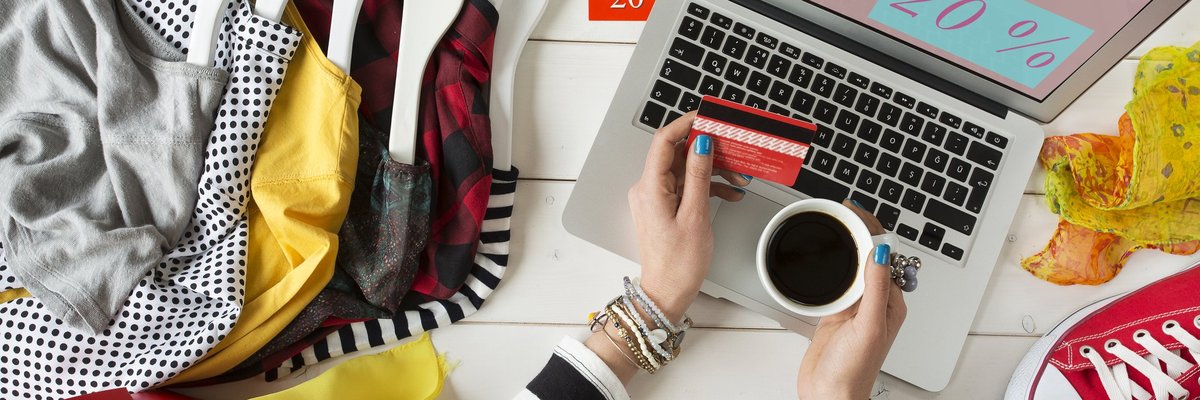 Woman at a laptop surrounded by shopping items