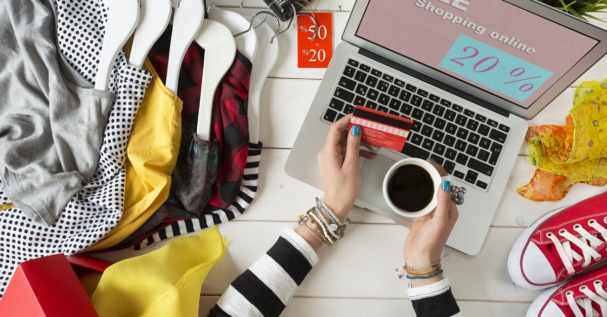 Woman at a laptop surrounded by shopping items