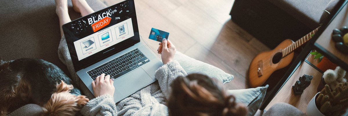 Woman black friday shopping from her couch at home on her laptop.