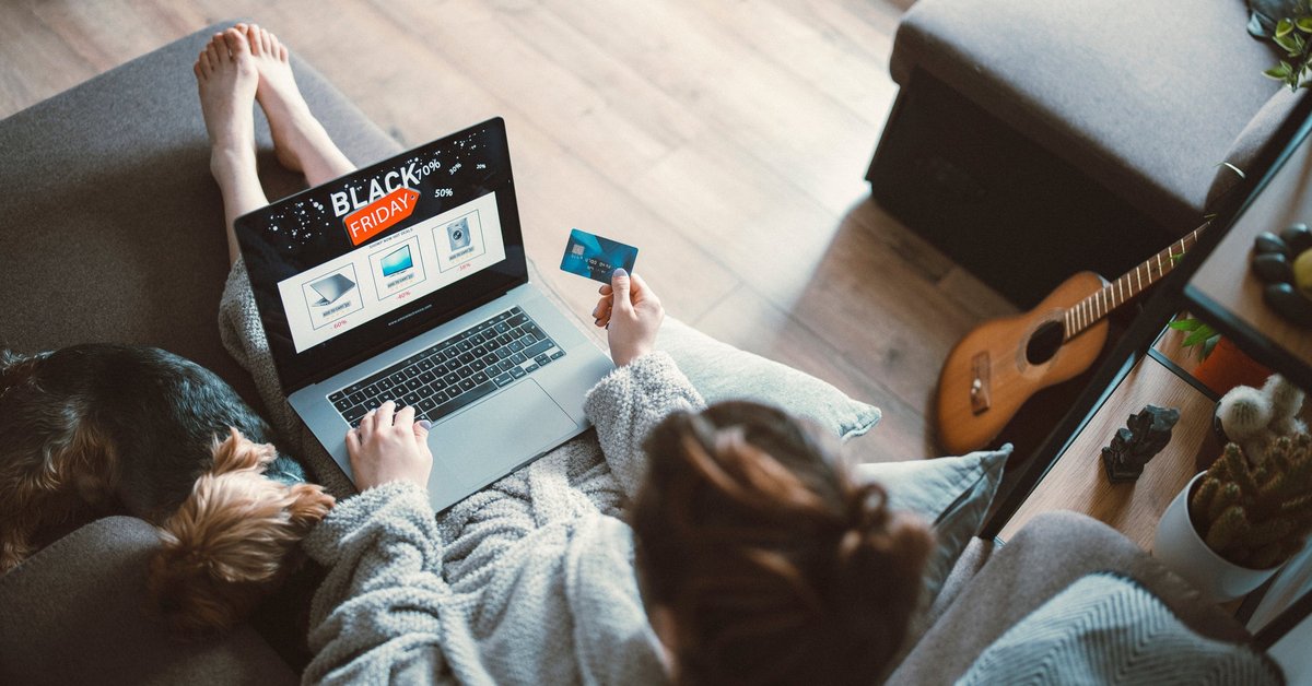 Woman black friday shopping from her couch at home on her laptop.