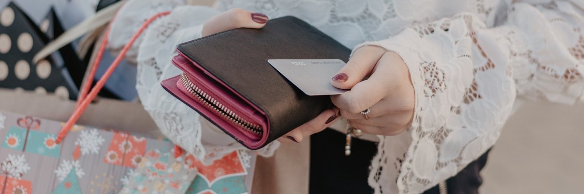 A woman holding shopping bags and a credit card.
