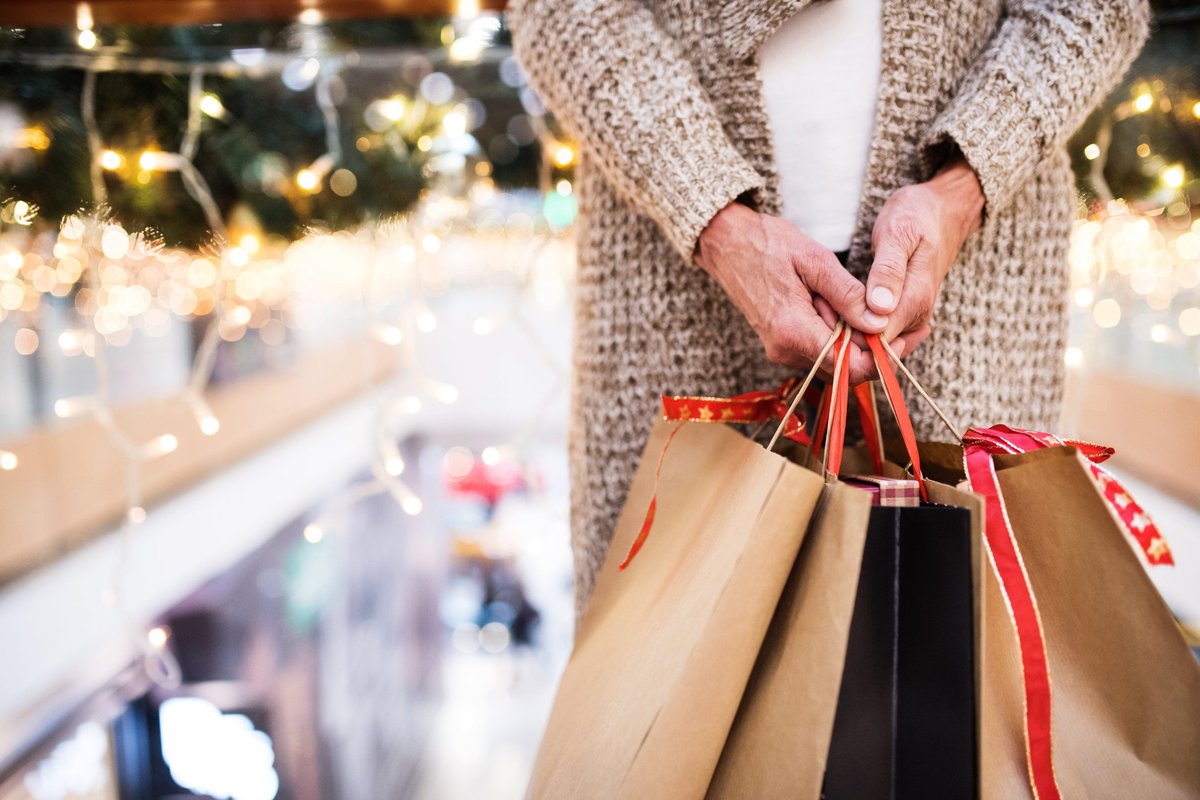 A woman holding shopping bags full of gifts.