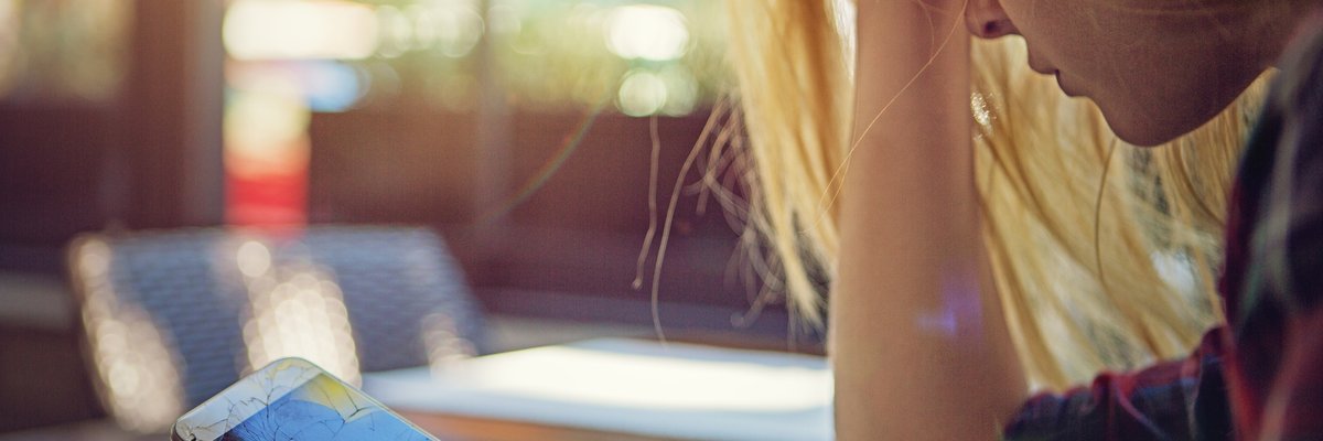 Woman holding smashed cell phone