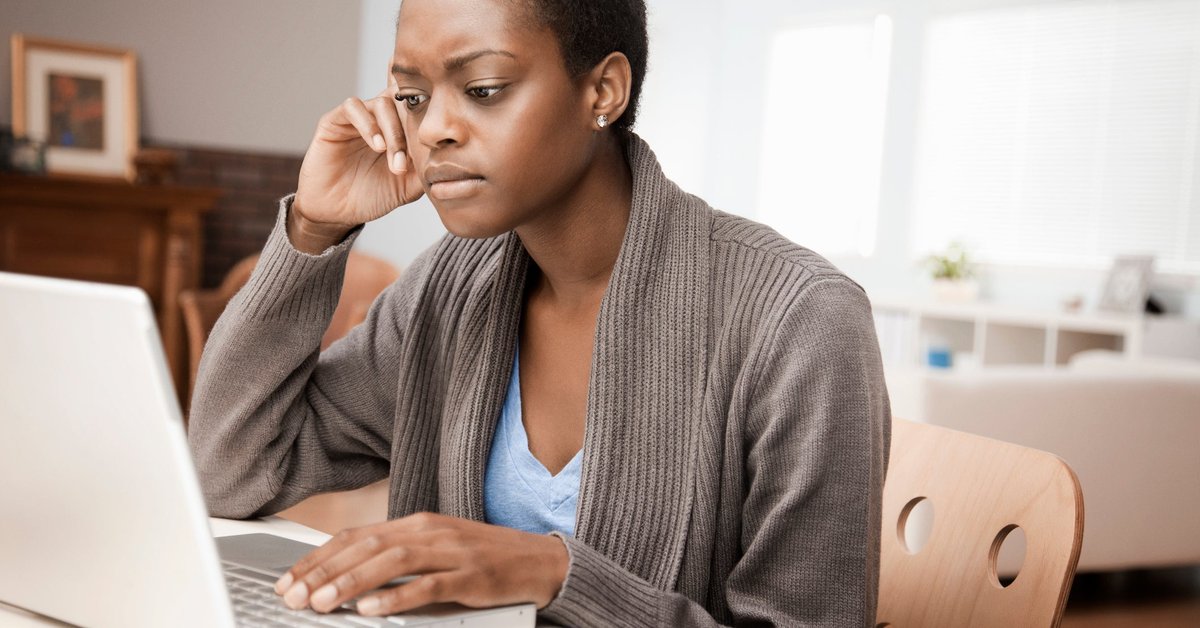 Woman looking at laptop with skeptical expression.