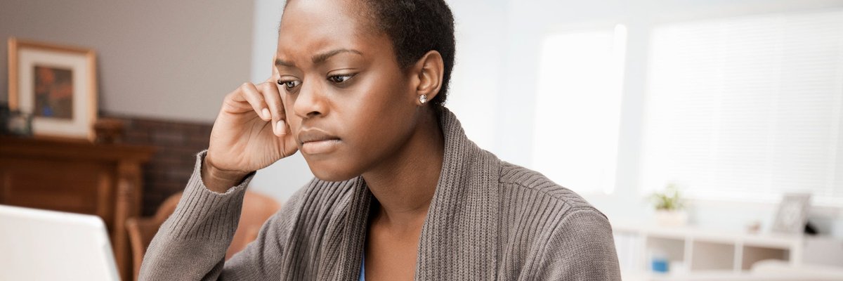 Woman looking at laptop with skeptical expression.