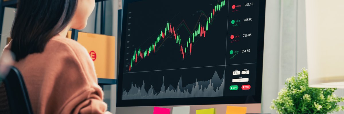 Woman looking at upward trending chart on computer