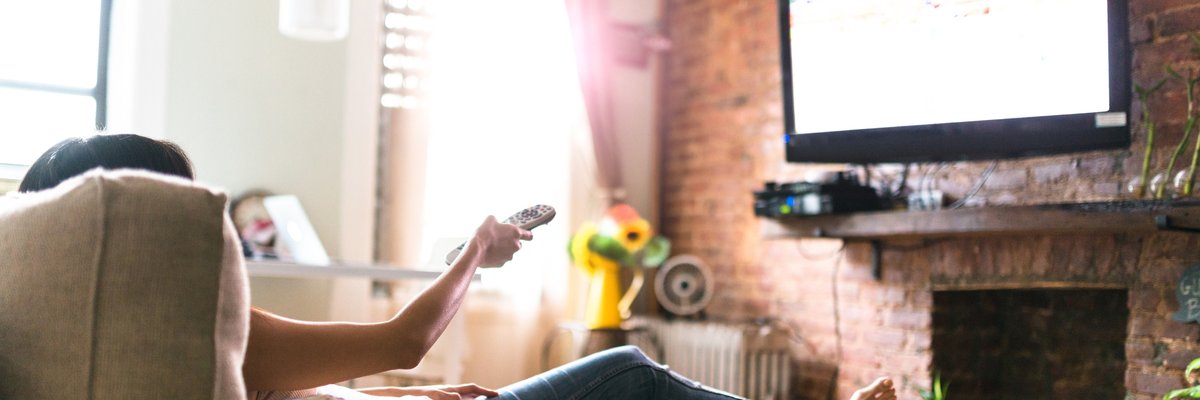 Woman lounging on her sofa watching tv.