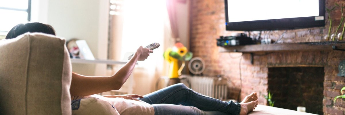 Woman lounging on her sofa watching tv.