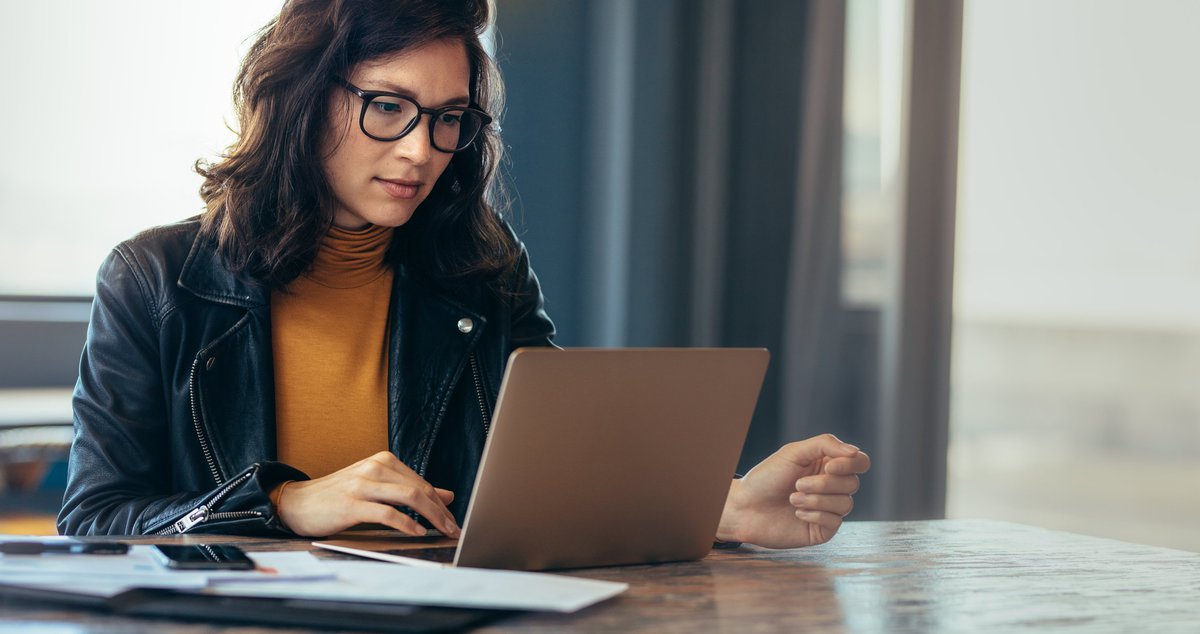 A woman on working on a laptop.