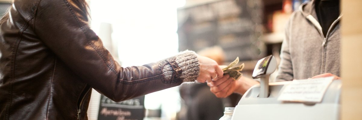 Woman paying for purchase with cash.