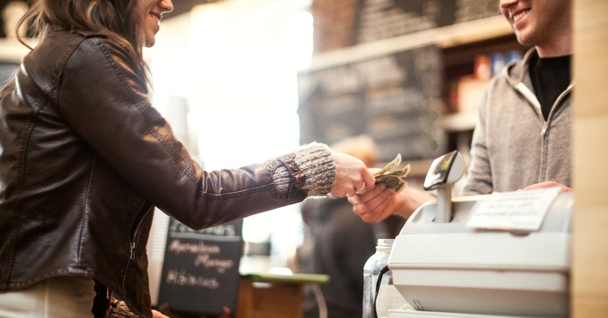Woman paying for purchase with cash.