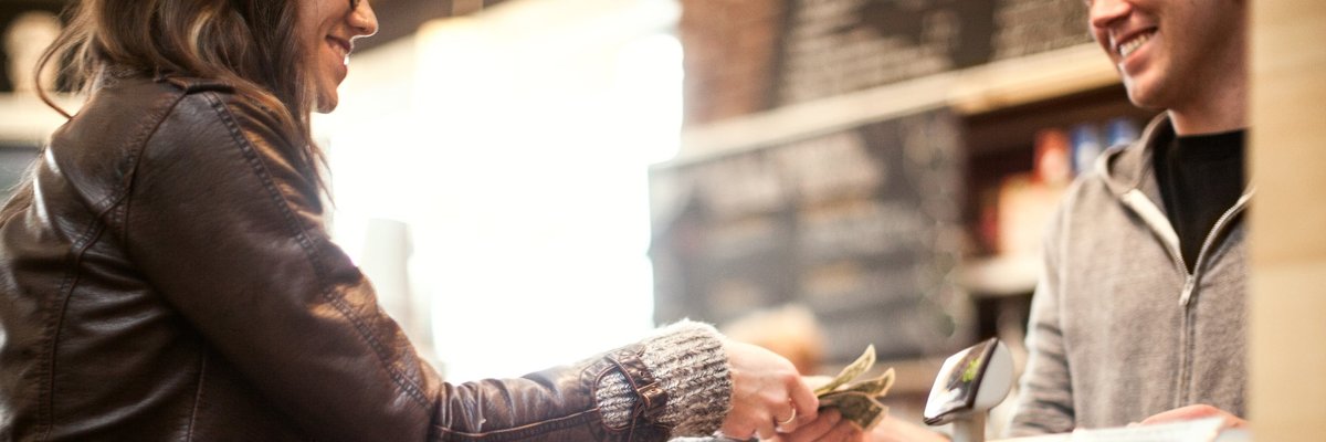 Woman paying for purchase with cash.