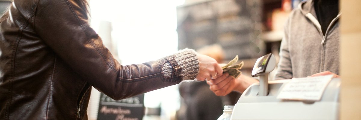 Woman paying for purchase with cash.