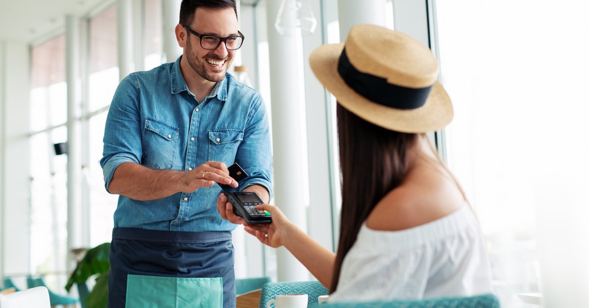 Woman paying waiter credit card
