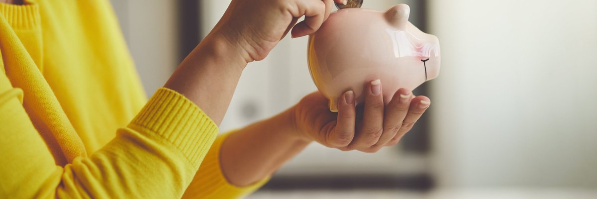 Woman putting money in piggy bank