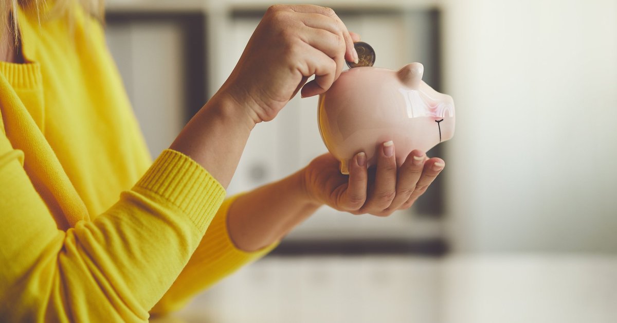 Woman putting money in piggy bank