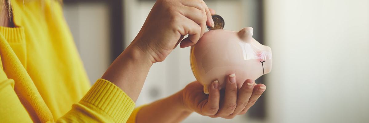 Woman putting money in piggy bank