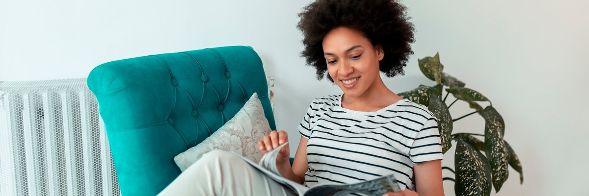 Woman reading magazine in a chair.