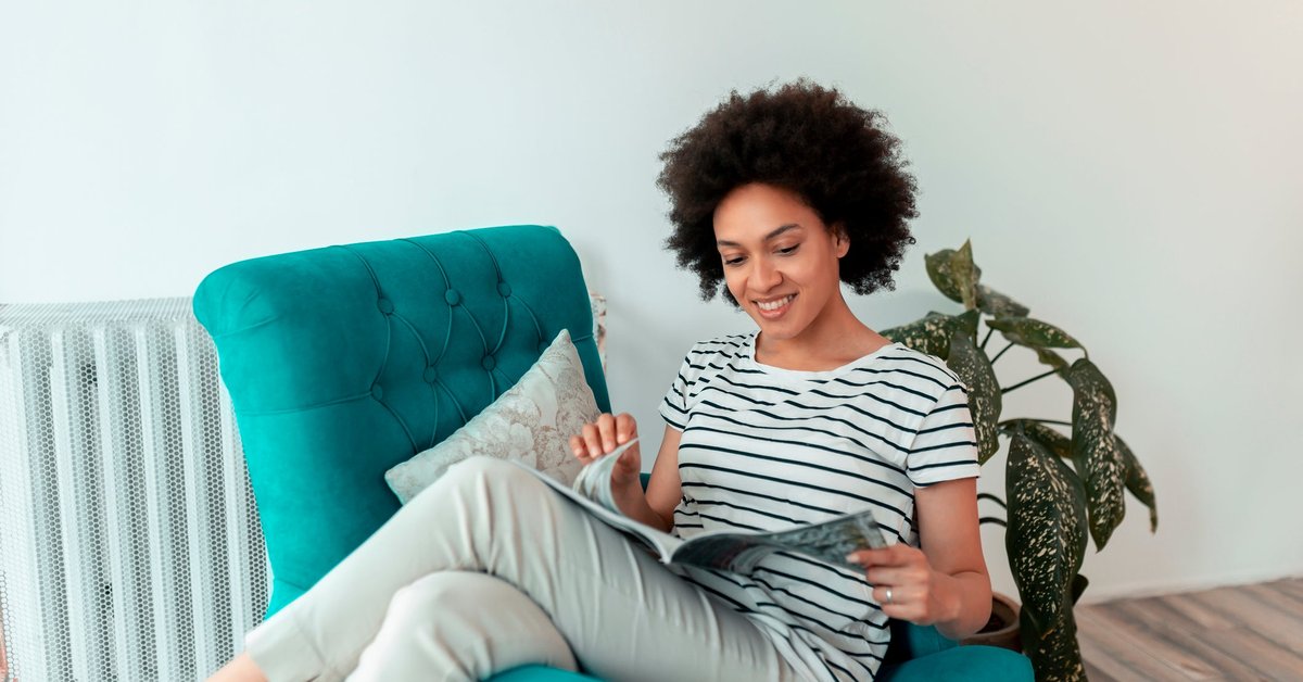Woman reading magazine in a chair.